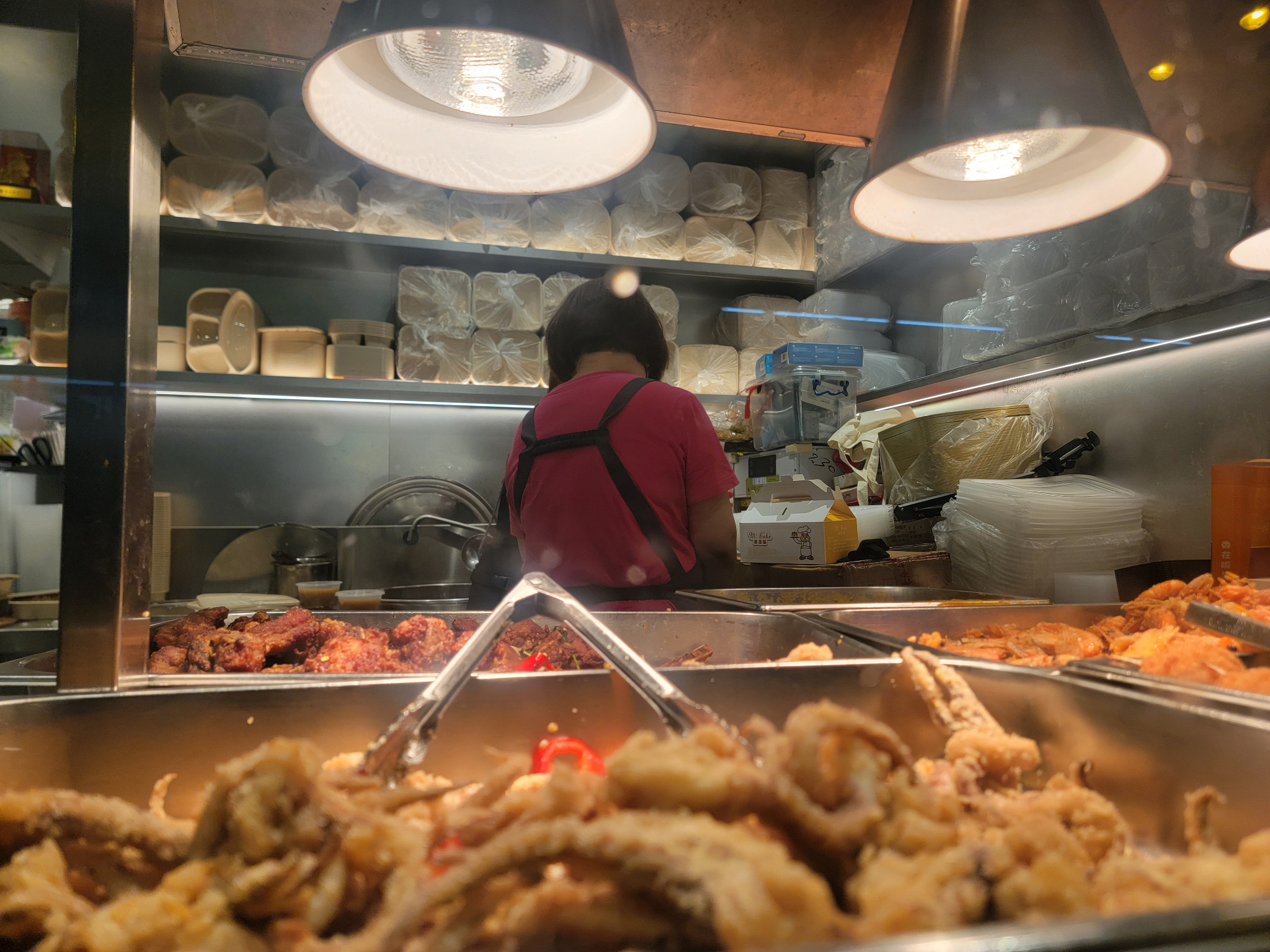 Fried snacks under heat lamps at a street-side stall.