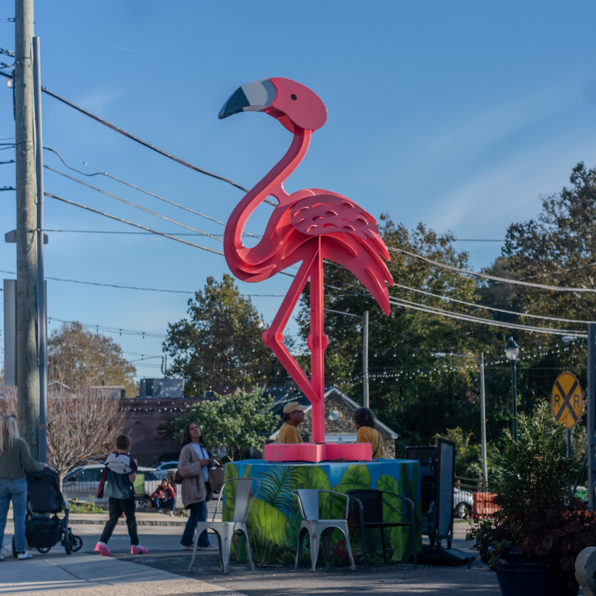 Bright pink flamingo statue at Chloe’s Corner against a blue October sky.