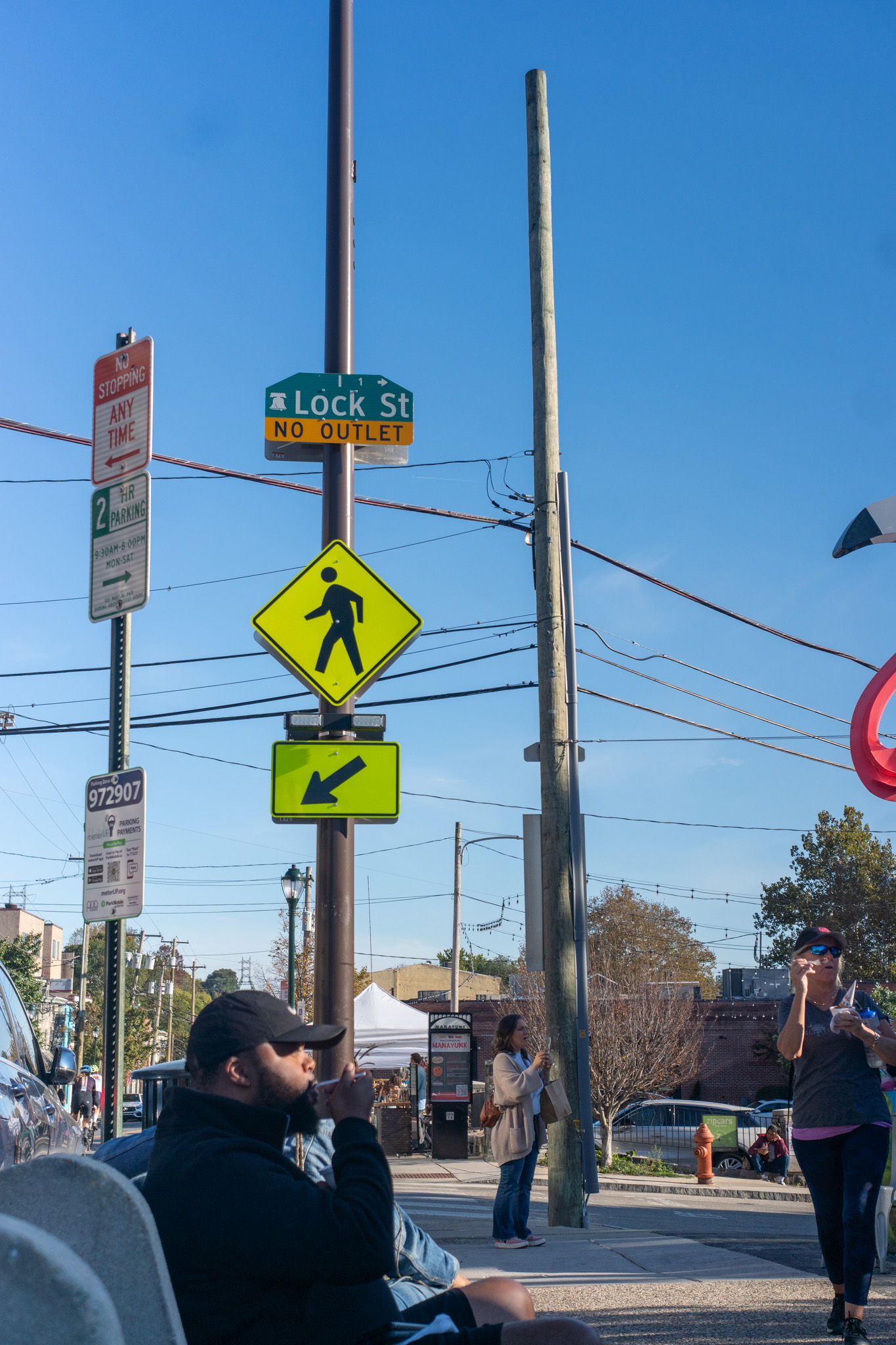 Lock Street sign and a small crowd relaxing along Main Street.