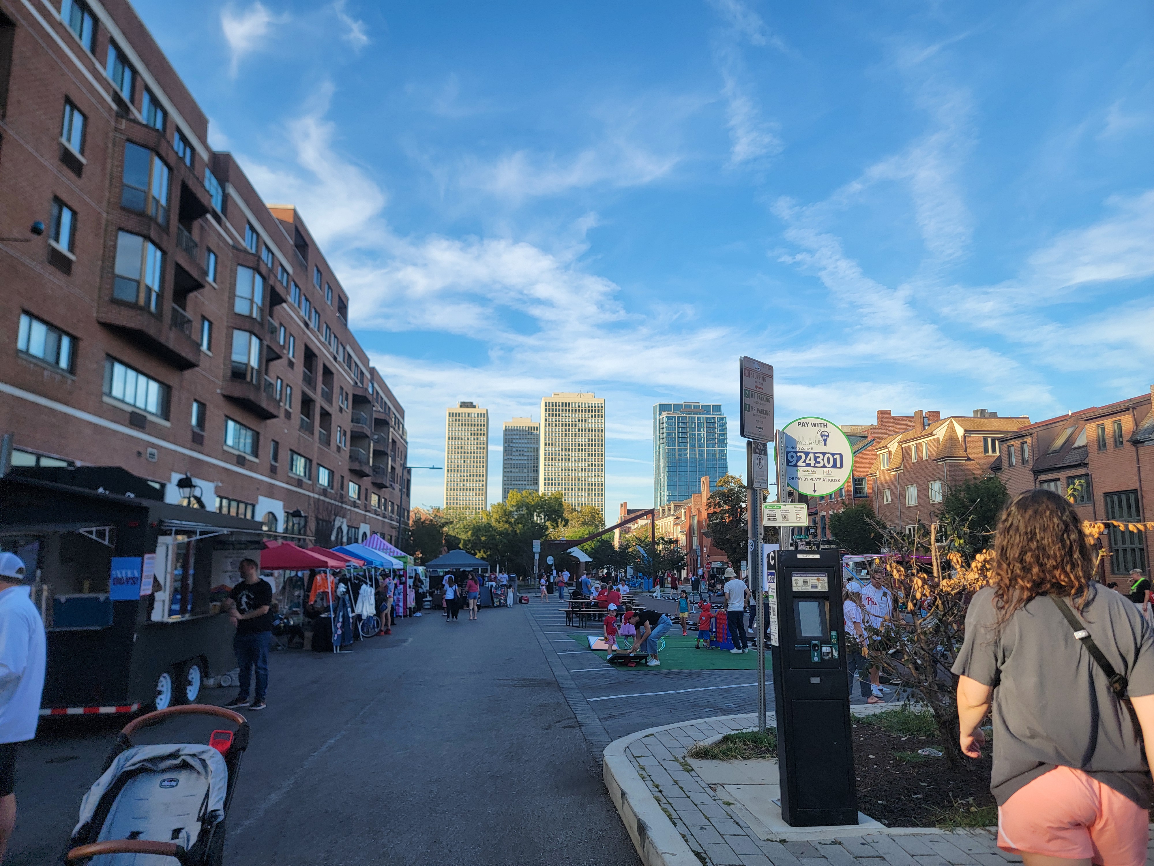 Open Streets on 4th Street in Queen Village, vendor tents and people strolling in evening light.